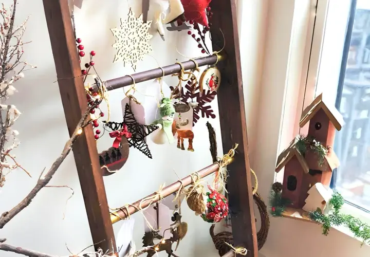 Eine Leiter weihnachtlich dekorieren: Sterne, Schneeflocken, Rentiere und Lichterketten schmücken die Sprossen.