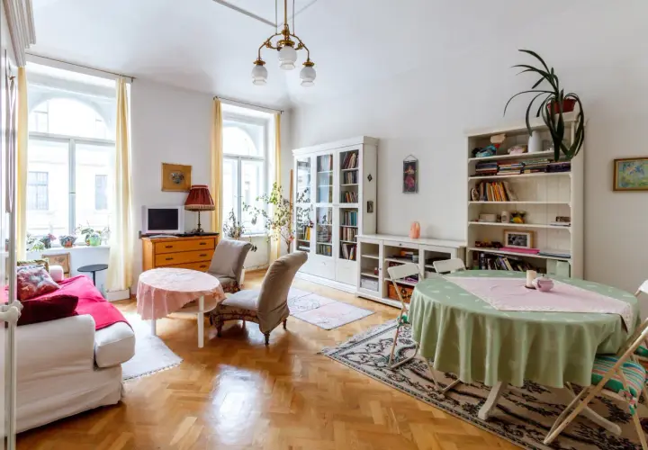 Przytulny salon z kanapą, dwoma fotelami, regałami i stołami. Idealne miejsce na umowa na czas nieoznaczony.