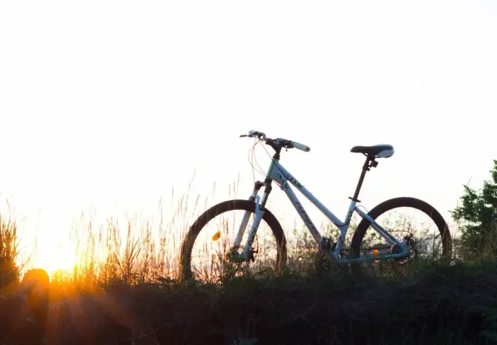 Bicicleta blanca en un prado al atardecer, lista para una aventura de cantabria en bici.