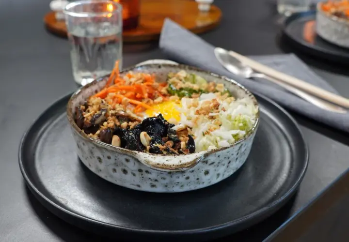 En vacker skål med bibimbap, fylld med ris, grönsaker, svamp och ett stekt ägg. Perfekt för ett snabbt och gott bibimbap recept.