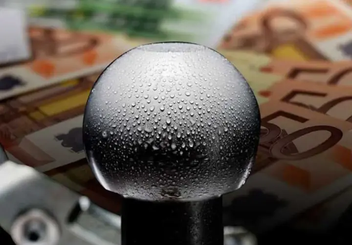 Gocce d'acqua su un gancio traino, con banconote in euro sullo sfondo. Quanto costa omologare un gancio traino?