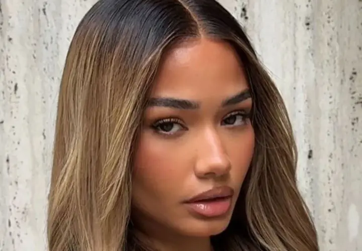 Mujer con cabello castaño oscuro con mechas rubias, un estilo que inspira cómo aclarar el pelo para un look radiante.