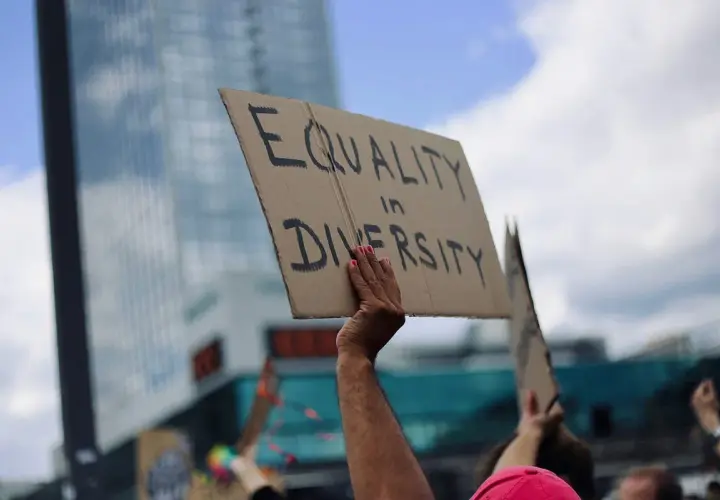 A hand holds a sign reading "EQUALITY in DIVERSITY," a powerful statement that inclusivity is a value.