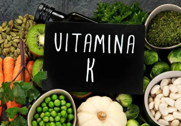 Variedad de alimentos ricos en vitamina K2: zanahorias, kiwi, semillas de calabaza, guisantes, coles de Bruselas, judías blancas y hierbas.