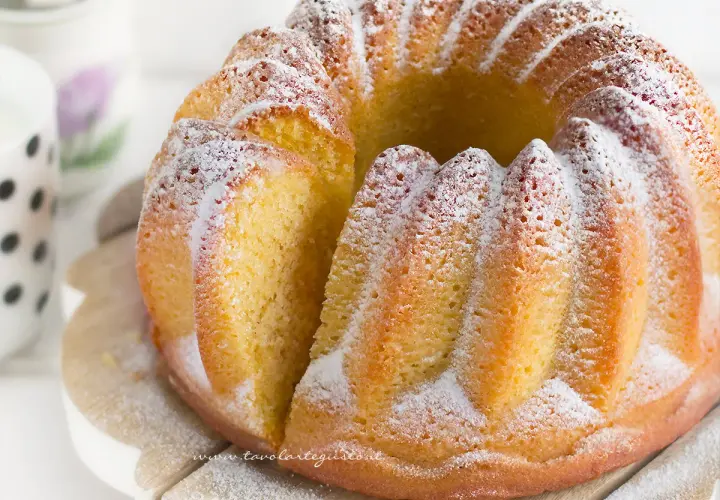 Un delizioso ciambellone soffice, spolverato di zucchero a velo, pronto per essere gustato.