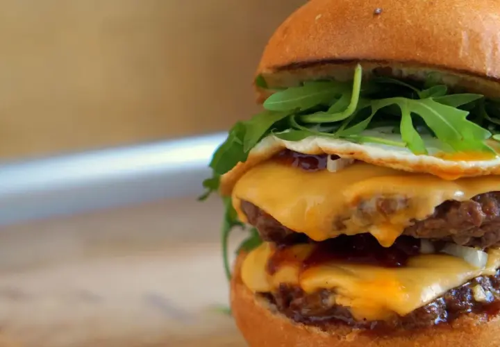 Pyszny McMuffin farmerski przepis: podwójny kotlet, ser, jajko sadzone, rukola i sos. Idealny na śniadanie!