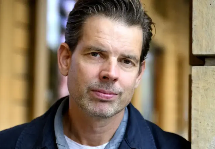 Alex Schulman, en svensk författare och programledare, poserar framför Dramaten.