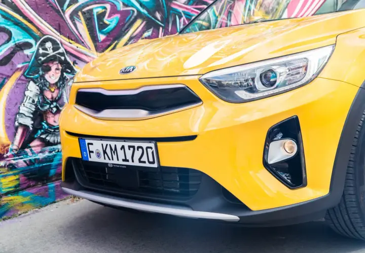 Żółty, stonic kia z pirackim graffiti w tle.