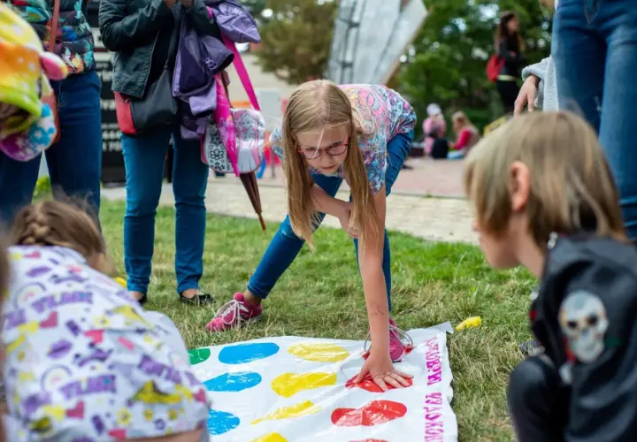 Bambini si divertono con giochi per feste di compleanno 11 anni, giocando a Twister sull'erba.