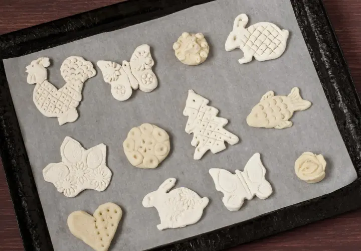 Figurki z masy solnej: kogut, motyl, królik, choinka, ryba, serce i kwiaty czekają na pieczenie.
