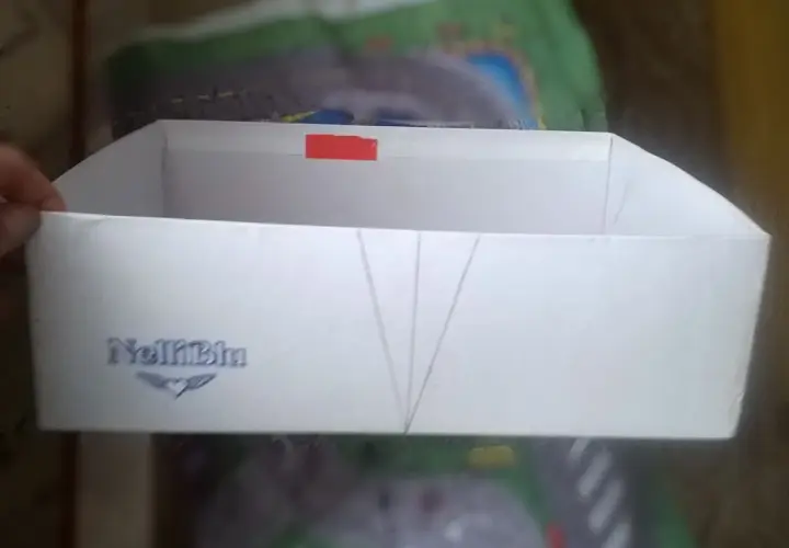 Białe pudełko z logo "NelliBlu" i zaznaczonymi liniami, gotowe do stworzenia własnego **organizer diy**.