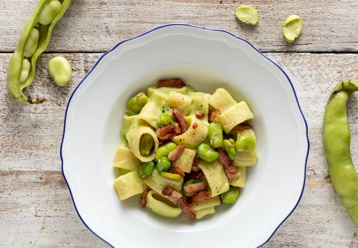 Piatto di pasta con fave fresche e croccante pancetta, un classico saporito.