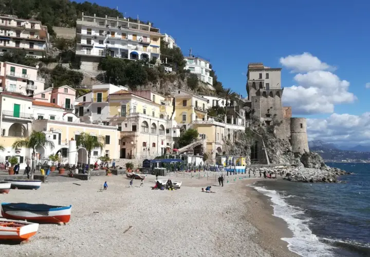 Vue pittoresque de Cetara, Italie, avec ses maisons colorées accrochées à flanc de colline et sa tour médiévale surplombant la mer.