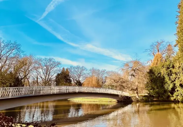 Eine Brücke über einen Teich im Bergpark Wilhelmshöhe. Hier kann man in Kassel spazieren gehen und die Natur genießen.