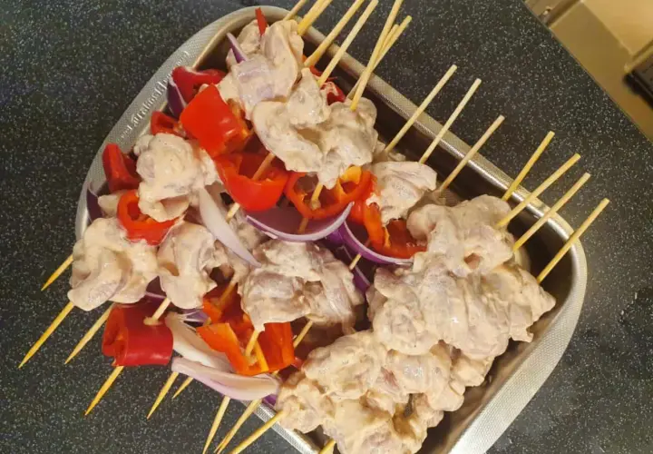 Shish tawook-spett på spett med kyckling, paprika och lök, redo att grillas.