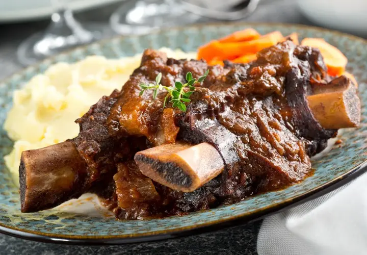 Plat de côte au four, tendre et savoureux, servi avec purée et carottes. Le temps de cuisson est parfait pour cette viande.