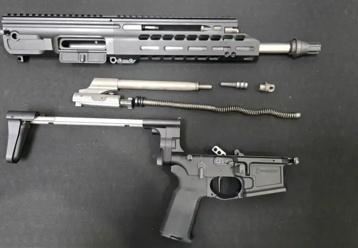 Rozłożony karabinek AR-15: górna i dolna część komory zamkowej, lufa, suwadło, sprężyna powrotna i inne części.