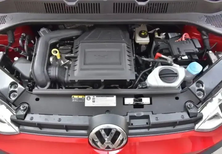 Silnik 1.0 TSI w czerwonym Volkswagenie. Widoczny jest układ dolotowy, akumulator i płyny eksploatacyjne.