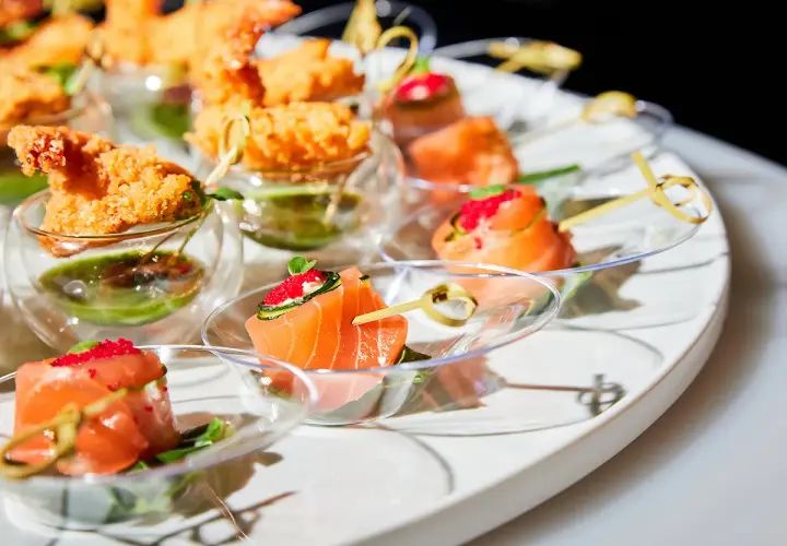 Un plateau d'apéro dinatoire américain avec des crevettes croustillantes et des roulés de saumon aux œufs de poisson.