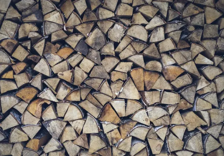 Stapel von gespaltenem Weidenholz, bereit als Brennholz für gemütliche Abende.