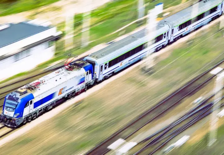 Pociąg Intercity pędzi po torach, oferując szybki sposób, jak dojechać z Krakowa do Dąbek nad morzem.