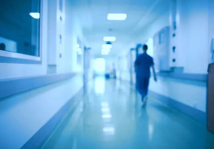 Un medico ospedaliero cammina in un corridoio. Chissà quanto prende di pensione dopo anni di servizio.