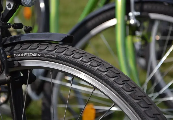 Szczegółowe zdjęcie opony rowerowej z napisem "TourRIDE". Dowiedz się, jak wymienić dętkę w rowerze, by szybko wrócić na trasę.