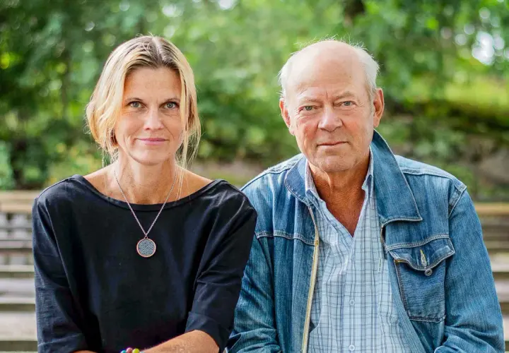 Anna Hedelius och en man sitter utomhus.