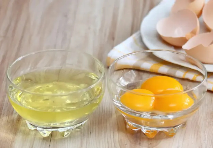 Deux bols en verre : l'un avec des blancs d'œufs, l'autre avec trois jaunes. Idéal pour tester le temps de cuisson des blancs en neige au micro-ondes.