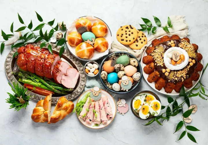 Wielkanocny stół pełen smakołyków: pieczona szynka, pascha, jajka, babki, ciasteczka i inne pyszności. Idealne co do jedzenia na wielkanoc.
