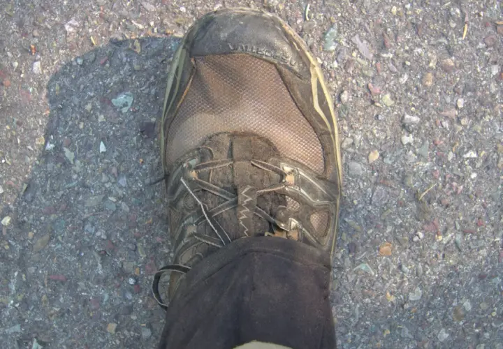 Dirty Gore-Tex hiking boot on gravel. Learn how to clean Gore-Tex shoes to keep them waterproof and ready for your next adventure.