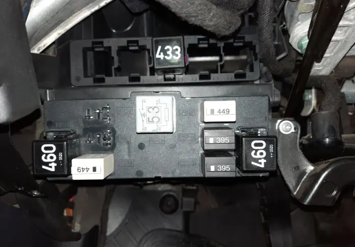 Skrzynka bezpieczników w Audi A3 8P. Widoczne przekaźniki i bezpieczniki, m.in. z oznaczeniami 460, 433, 395. Opis bezpieczników jest kluczowy.