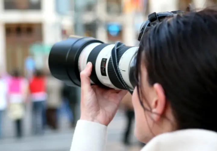 Kobieta z aparatem, gotowa do uchwycenia chwili. Inspiracja dla każdego bloga o fotografii.