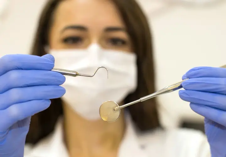 Igienista dentale con strumenti, un'idea di quanto guadagna un igienista dentale privato.