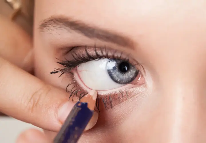Aplicando delineador en la linea de agua del ojo, creando un look intenso.