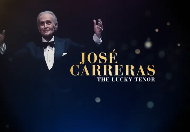 José Carreras w smokingu z uniesionymi rękami, na ciemnym tle z tekstem.