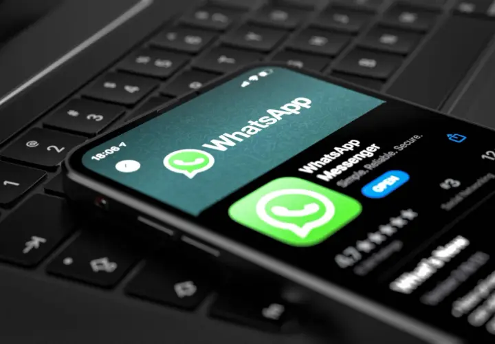 Telefon z aplikacją WhatsApp na klawiaturze laptopa. Wygodny sposób na korzystanie z WhatsApp na komputerze.