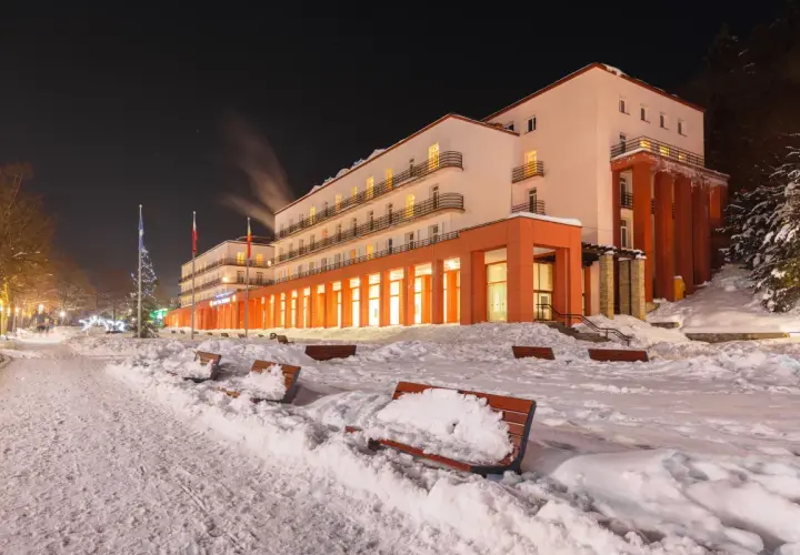 Zimowy wieczór przed sanatorium. Warto sprawdzić nowe zasady wyjazdu do sanatorium na NFZ, by cieszyć się wypoczynkiem.