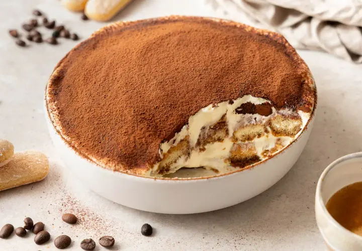 Un invitante tiramisù, una soffice mousse al cioccolato cosparsa di cacao, con savoiardi inzuppati e crema.