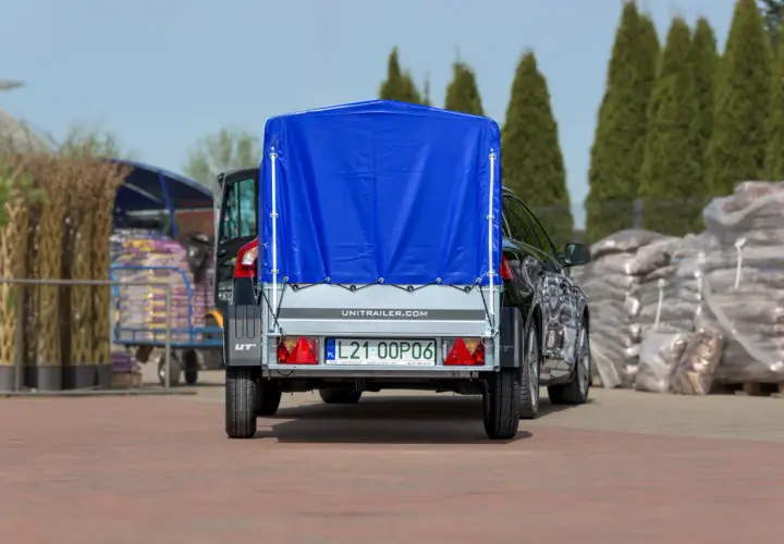 Ciężarówka z naczepą, przykryta niebieską plandeką, gotowa do transportu. Zastanawiasz się, ile waży ciężarówka z naczepą?