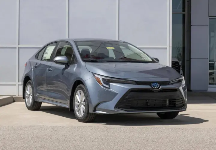 Grigio Toyota Corolla, un'auto a metano ecologica, parcheggiata davanti a un edificio moderno.