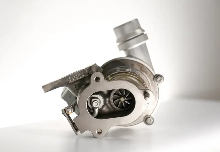 Metalowa turbosprężarka z widocznymi łopatkami wirnika. To serce każdego silnika, które dzięki technologii turbo compound zwiększa moc.