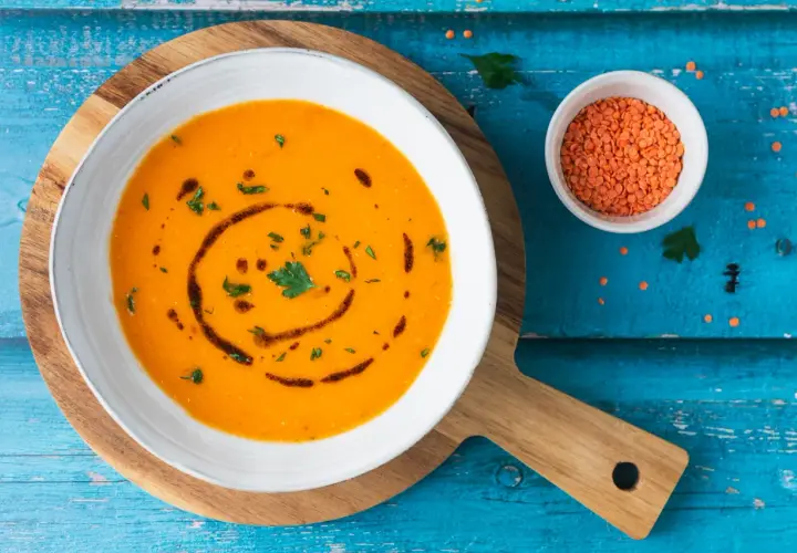Ciorba turca ricetta originale: zuppa di lenticchie rosse cremosa, guarnita con prezzemolo e olio.