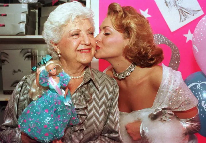 Ruth Handler, skaparen av Barbie, får en kyss av en ung kvinna. Barbie-dockan syns i bilden.
