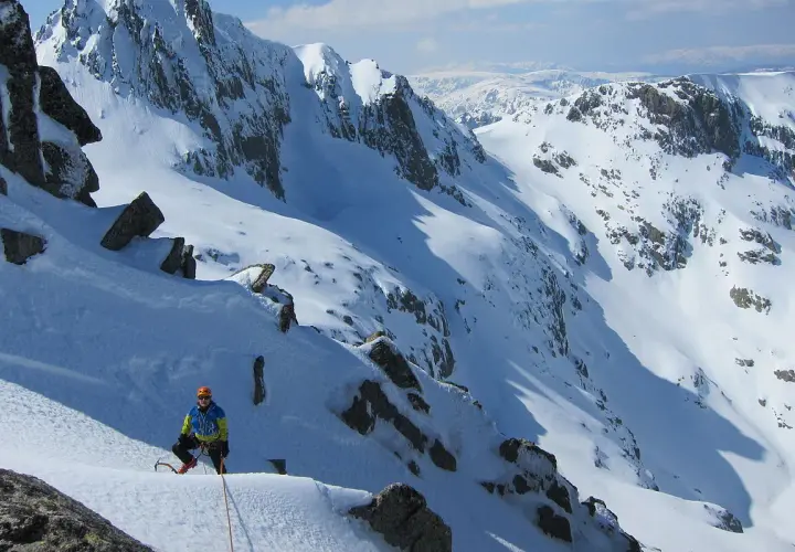 Alpinista en pendiente nevada, listo para ascender. Una escena perfecta para cursos de alpinismo.