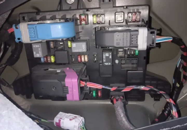 Panel bezpieczników w Opel Astra J, z widocznymi bezpiecznikami i przekaźnikami.