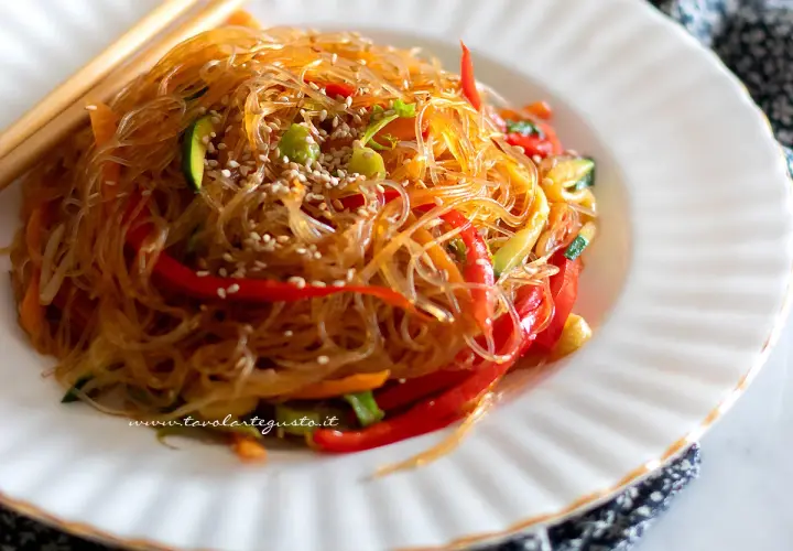 Spaghetti di soia con verdure colorate, un piatto leggero e gustoso, guarnito con semi di sesamo.