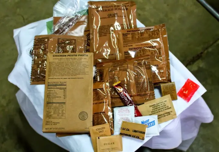 MRE polskie: paczka z daniem "Chicken Pesto Pasta", ciastka, napój, cukier, sól, pieprz i inne dodatki.