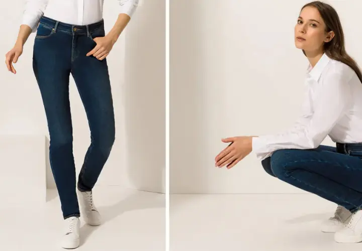 Zwei Frauen in Jeans und weißen Hemden, eine stehend, die andere hockend.