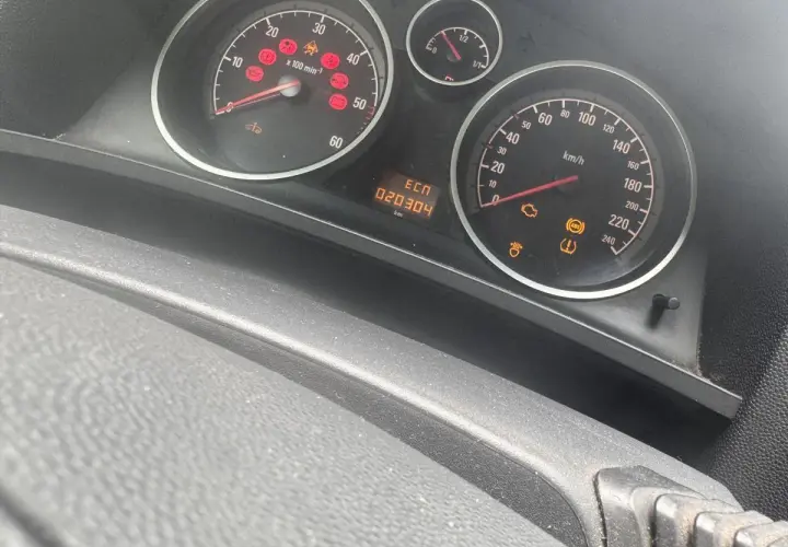 Kontrolka samochód z kluczykiem Opel świeci się, wskazując problem z immobilizerem lub kluczykiem. Na desce rozdzielczej widoczne są też inne kontrolki.